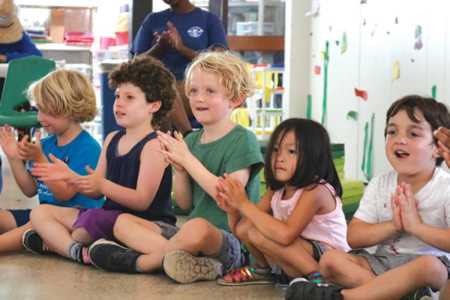 children sitting on the floor clapping