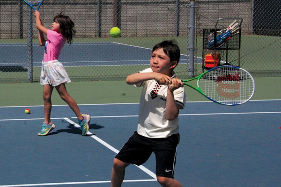 two children playing tennis